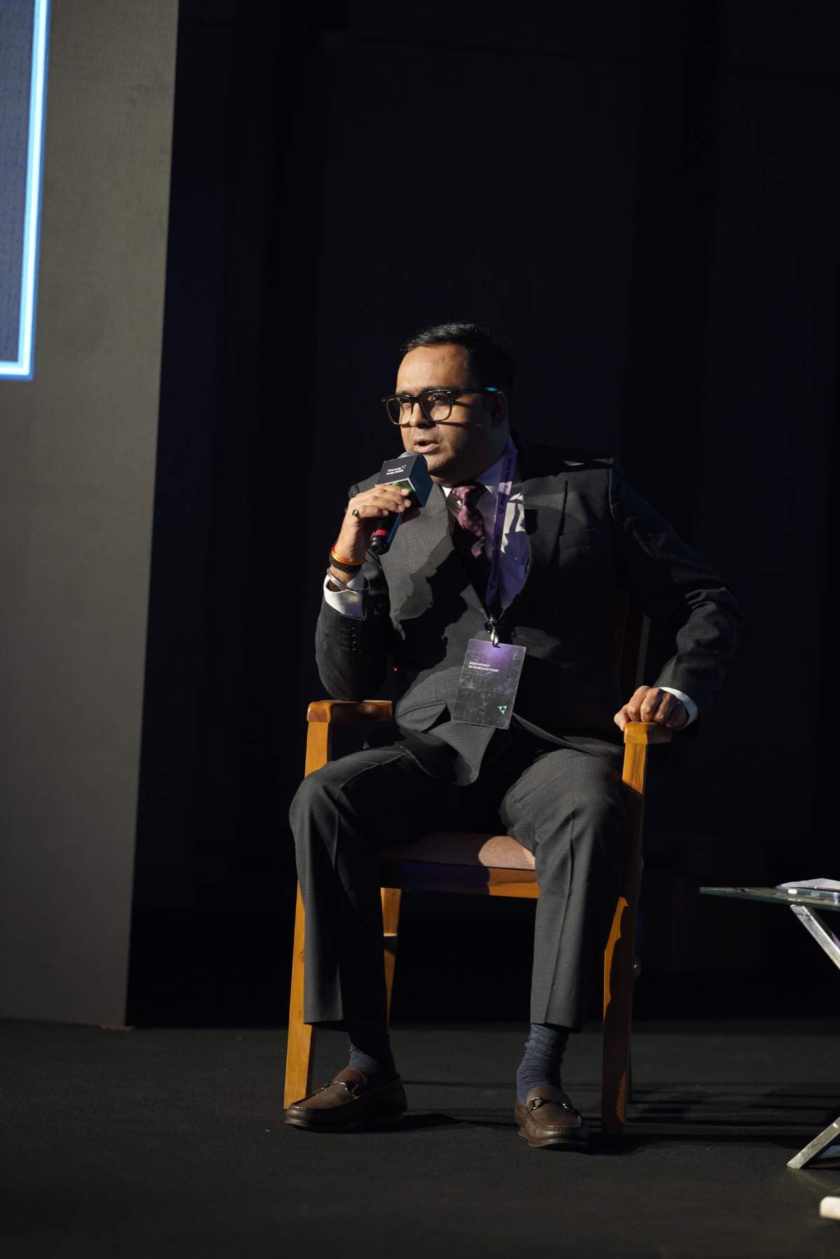 A speaker answering into a microphone during a seated fireside session