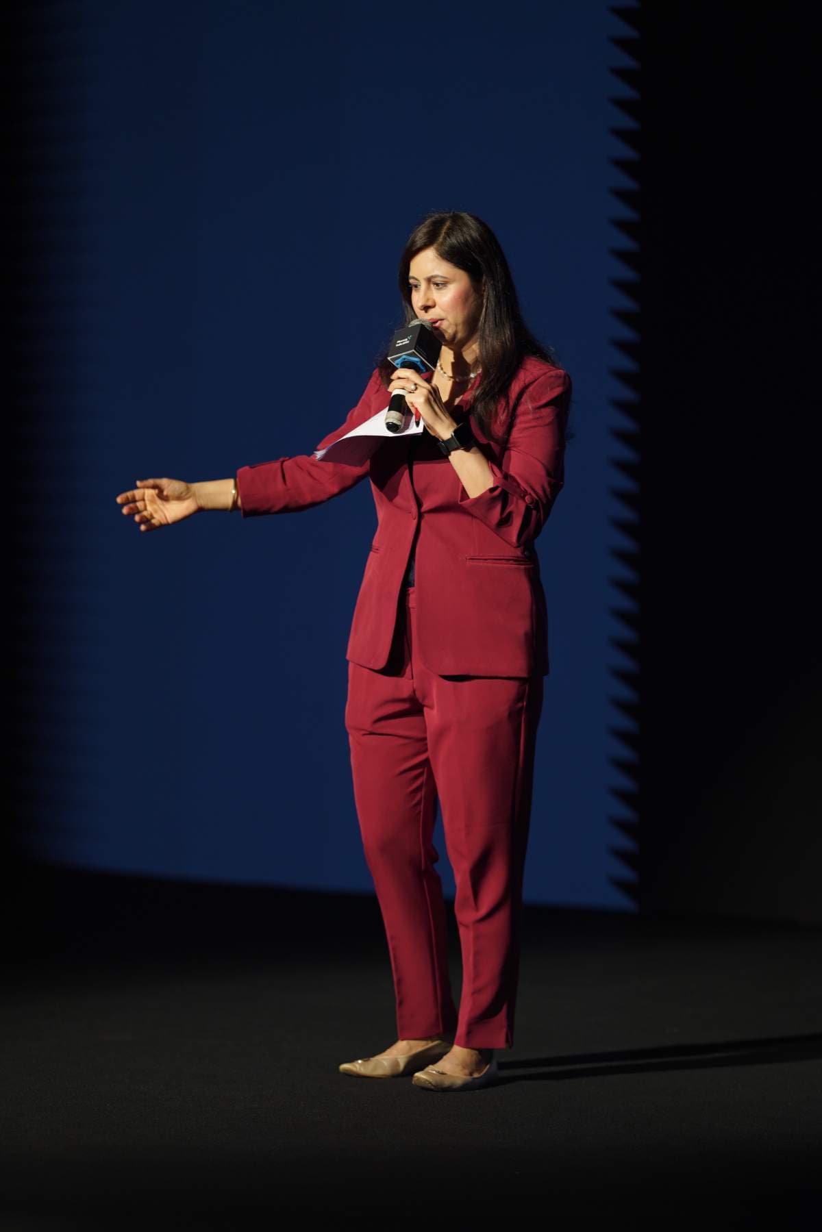 The host addressing the room from the stage at Pharmig India 2025